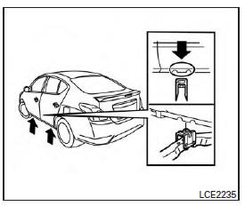 Jacking up vehicle and removing the damaged tire